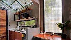 Una cucina moderna con un'ampia finestra, mobili in legno e un bancone con sgabelli.