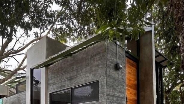 Loft moderno e minimalista di lusso, con facciata in pietra, ampie finestre e interni in legno.