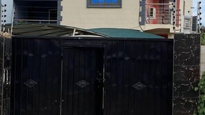 A two-story building with a beige facade, a blue window, and a red balcony. - Serenity Retreat in Ashongman Estate (North Legon)