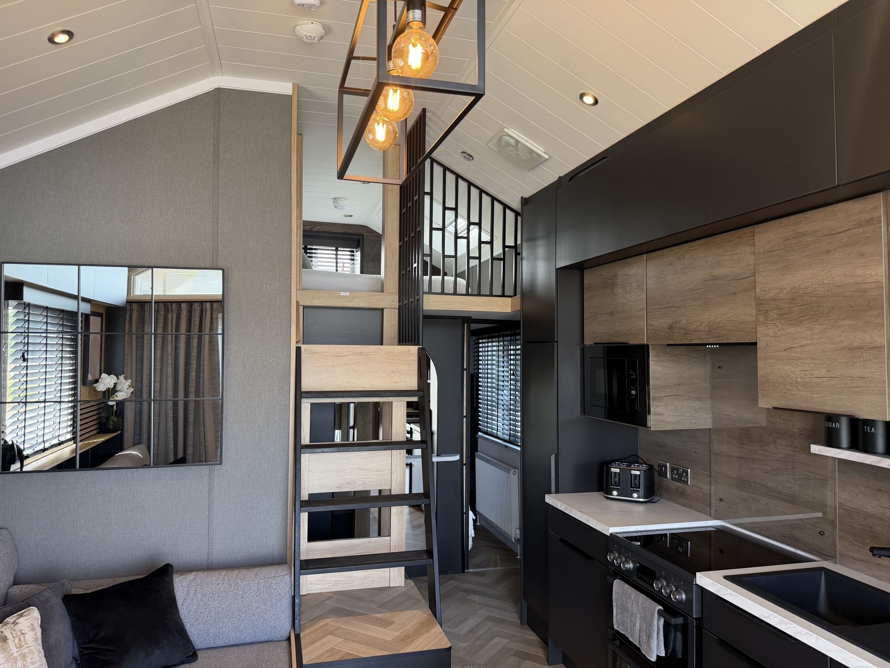 A modern kitchen with a built-in oven, a black stove, and a countertop with a toaster.