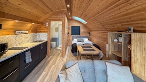 Un interior acogedor de madera con cocina, comedor y zona de descanso.