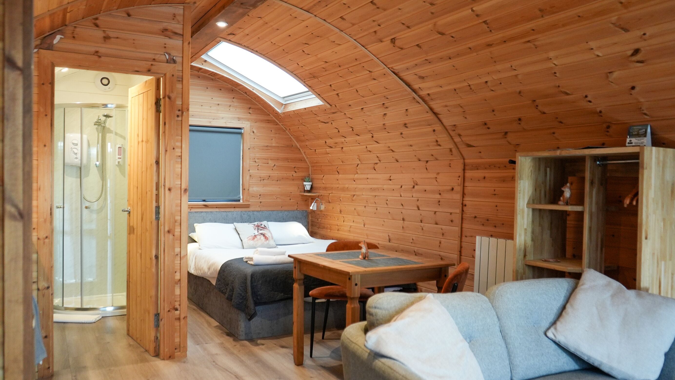 Una cabaña acogedora con un dormitorio en el altillo, un pequeño comedor y un espacio de descanso.