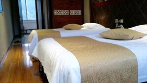 A hotel room with three beds, a wooden floor, and a patterned wall. - Sanmen Longyoujia Boutique Hotel (Sanmen)
