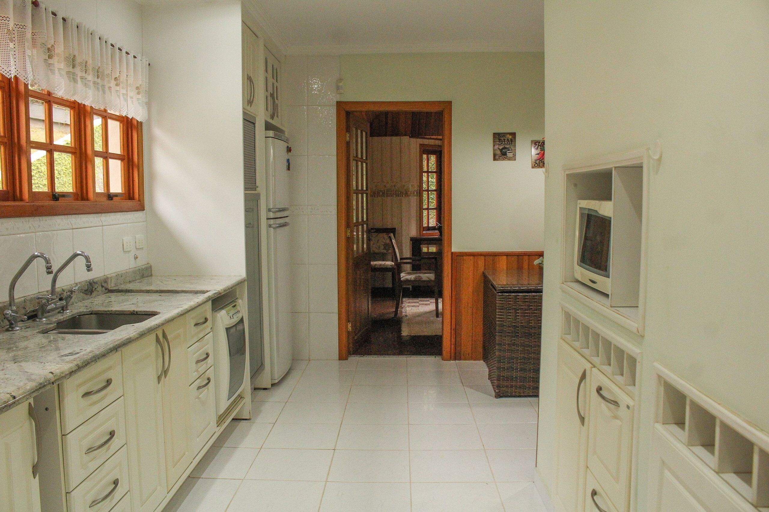 A kitchen with a sink, stove, and cabinets.