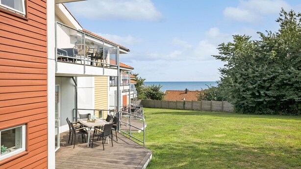 A modern apartment with a balcony overlooking a grassy yard and a view of the sea. - Gudhjem Søpark Lejl. 51 (Gudhjem)