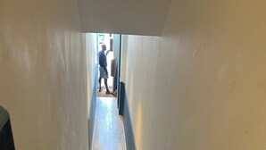 A staircase leading to a landing with a person standing at the top.