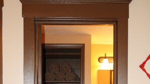 A narrow hallway with wooden flooring leading to a bathroom with a sink and a mirror. - The Farm House - Quiet Country Retreat! Great for Any Season - Pet Friendly! (Osborn)