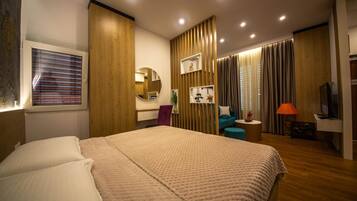 Een moderne hotelkamer met een groot bed, een bureau, een stoel, een televisie en een badkamer met douche en toilet.