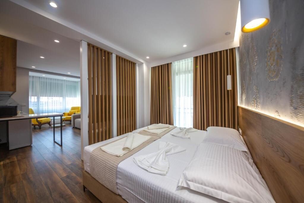 Et moderne hotelværelse med en stor seng, et skrivebord og udsigt over byen.