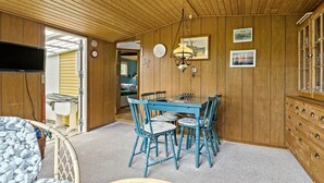 Ein Essbereich mit Holzboden, einem Tisch mit Stühlen und einer Deckenleuchte.