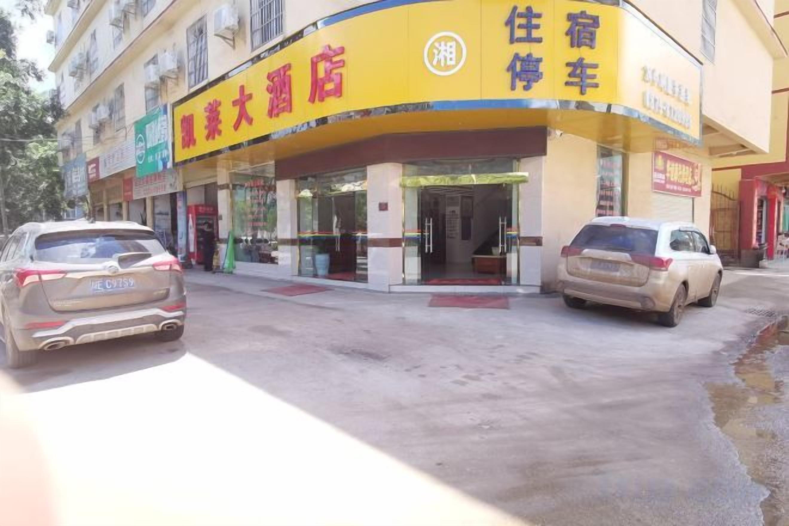 A building with a yellow and blue sign indicating a hotel and a car rental service.