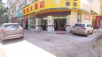 A building with a yellow and blue sign indicating a hotel and a car rental service.