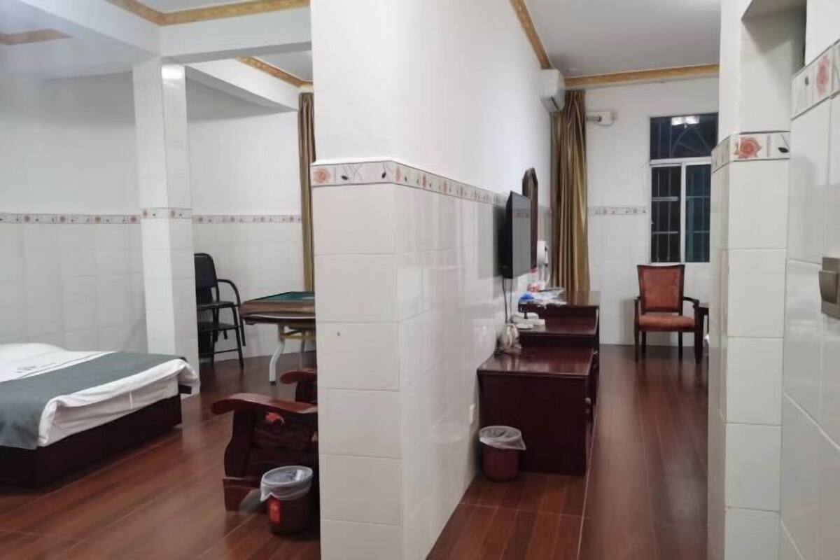 Ein Hotelzimmer mit Bett, Schreibtisch, Stuhl, Fernseher und Fenster.