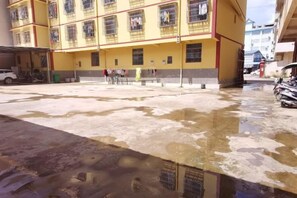 Un edificio amarillo de varios pisos con un patio.