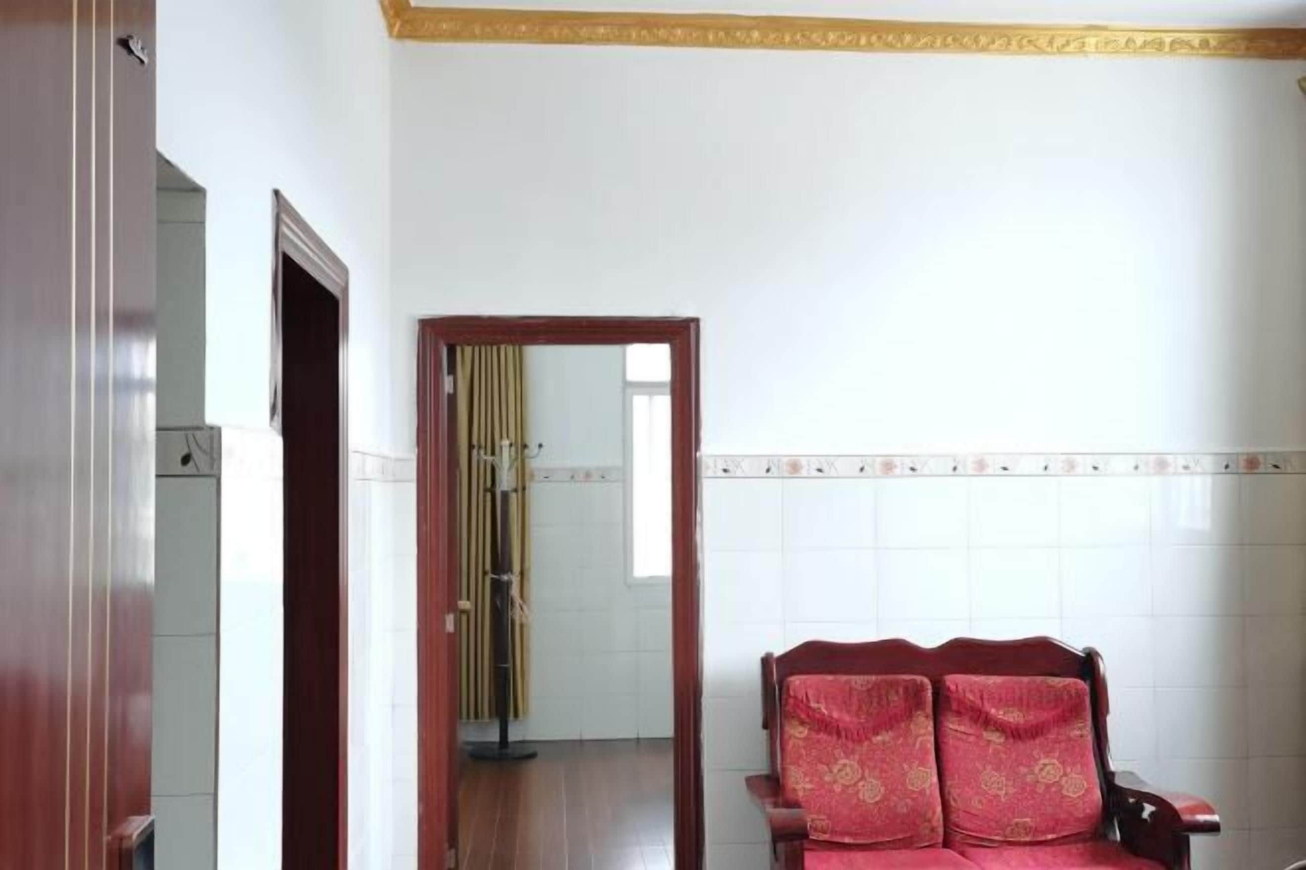 A room with a wooden chair, a mirror, and a tiled wall.