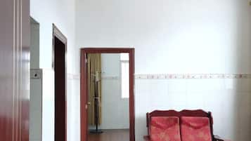 A room with a wooden chair, a mirror, and a tiled wall.