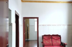 Una habitación con una silla de madera, un espejo y una pared con azulejos.