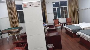 Ein Hotelzimmer mit Bett, Schreibtisch, Stuhl, kleinem Tisch und Billardtisch.