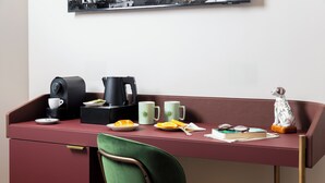 A neatly arranged desk with a coffee maker, mugs, a book, and a decorative dog figurine.