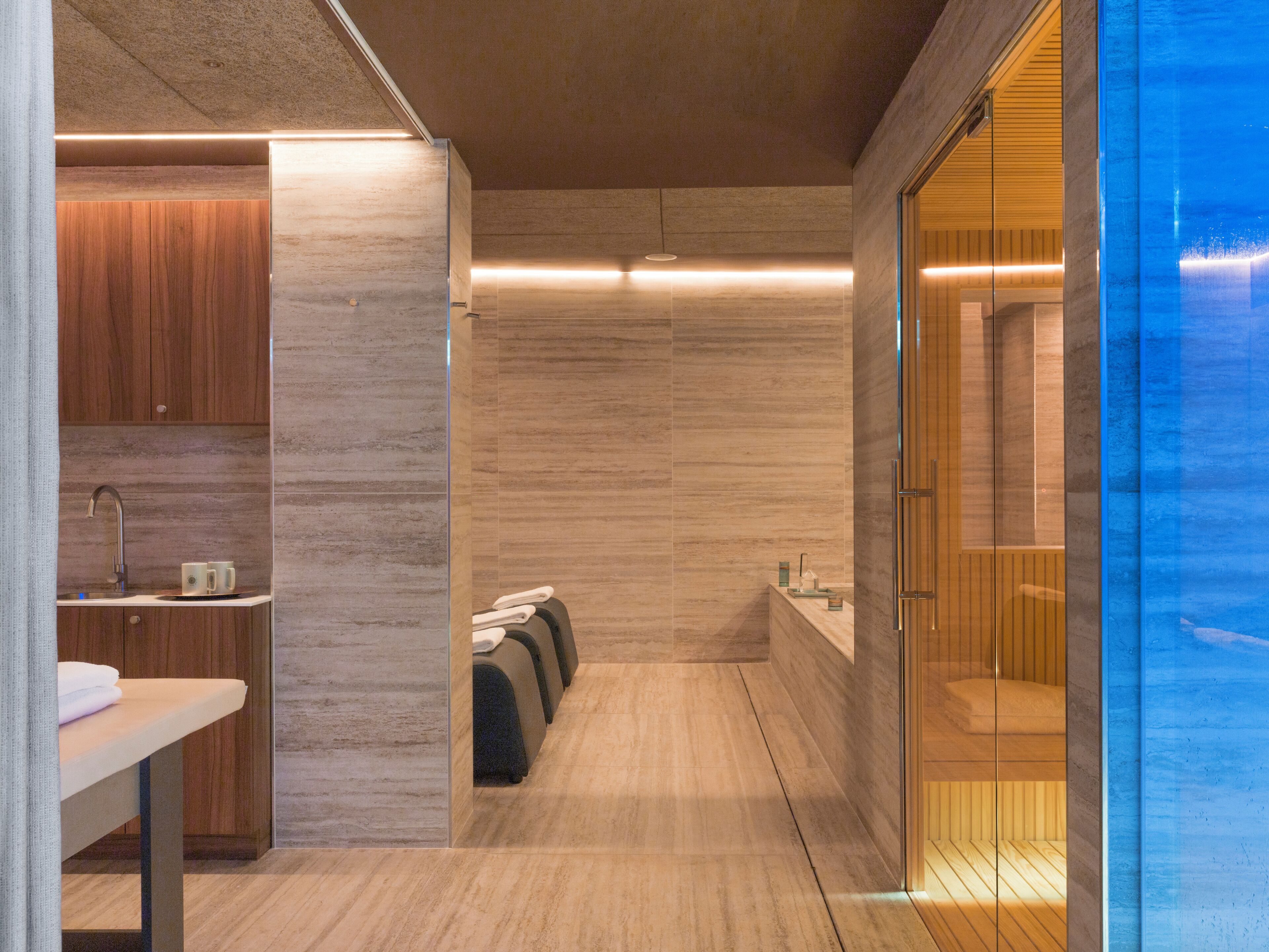 Ein modernes Badezimmer mit einem Holzkosmetikschrank, einem Waschbecken und einer Duschkabine aus Glas.