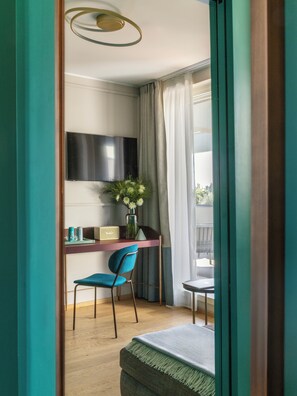A room with a desk, chair, television, and a window with curtains. - Adoro Hotel  (Rome)