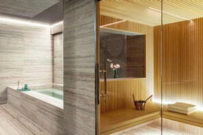 A modern bathroom with a marble bathtub, a wooden vanity, and a glass shower enclosure. - Adoro Hotel  (Rome)