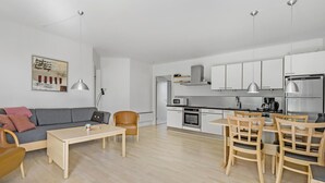 Een modern appartement met een zithoek, eethoek en keuken.