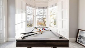 A pool table in a room with large windows and a framed picture on the wall. - Stunning 5 Bedroom Large Apartment With Parking (Edinburgh)