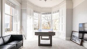 A room with a pool table, a black leather sofa, and large windows with a view of trees. - Stunning 5 Bedroom Large Apartment With Parking (Edinburgh)