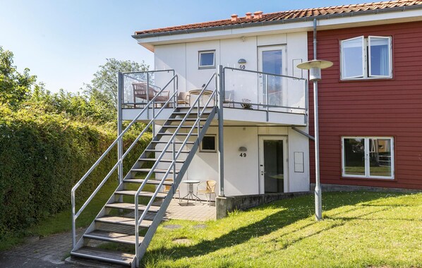 Un bâtiment à deux étages avec un escalier métallique menant à un balcon.