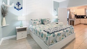 A bedroom with a bed, bedside tables, a nightstand, a lamp, a wall-mounted shelf with decorative items, and a ceiling fan. - Storey Lake Amazing Water view, Game Room, Movie Room and Theme Rooms (Kissimmee)