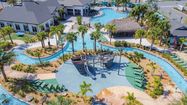 A resort with a large central pool, multiple smaller pools, and a water slide. - Storey Lake Amazing Water view, Game Room, Movie Room and Theme Rooms (Kissimmee)
