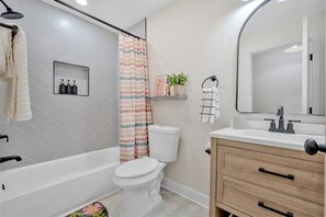 Un baño moderno con bañera, inodoro y tocador.