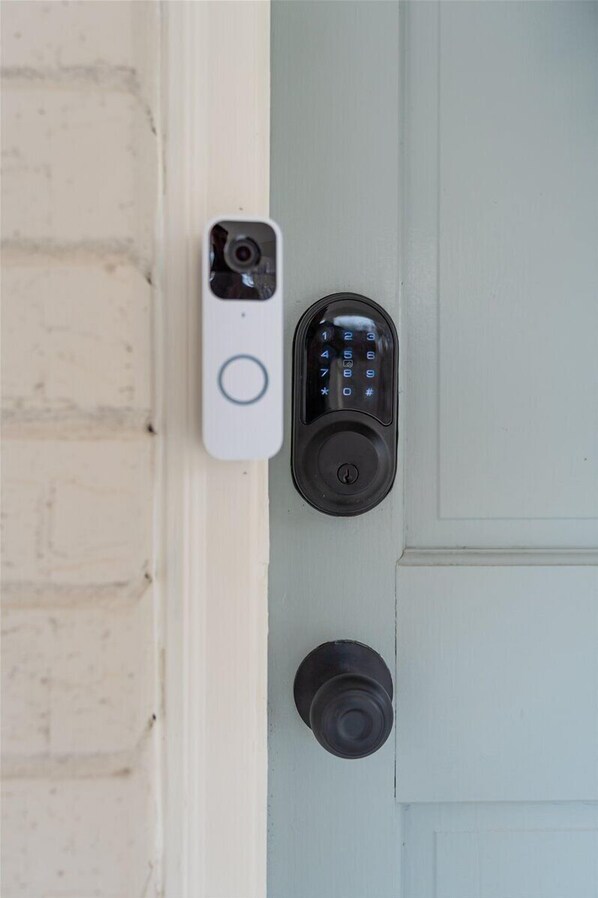 Una puerta con un teclado electrónico de combinación numérica y un sistema de intercomunicación instalado en la pared.