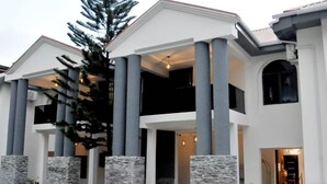 A modern two-story building with a symmetrical facade, large columns, and a central entrance. - THE ADDRESS HOTEL AND TOWER (Abuja)