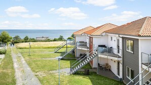 Un edificio costero con balcón, una escalera y vista al mar.