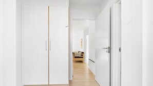Un couloir avec une armoire, un lit et une porte.