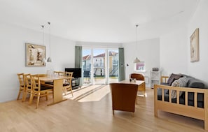Relax in this inviting living room with a dining area and sliding door leading to a balcony with a view.