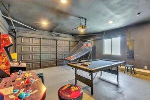 Enjoy games and entertainment in this indoor recreational area with a pool table, arcade games, and projector.