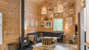 A cozy cabin interior with a wooden interior, a sofa, a dining table, and a fireplace. - 3 bedroom gorgeous home in Skals (Skals)