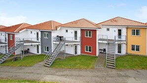 Una hilera de edificios modernos, de varios pisos, con escaleras externas y balcones.