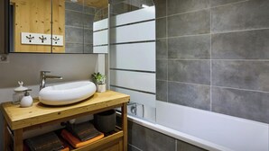 A modern bathroom with a white sink, wooden vanity, and a large mirror. - Le Petit Capricia - Aravis mountain stay for 8 - OVO Network (La Clusaz)