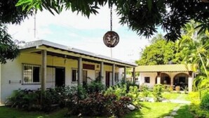 Un bâtiment à deux étages doté d’un porche abrité et d’un jardin.