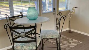A dining area with a round table, four chairs, a decorative vase, and a bird sculpture. - Prime Location, 2 Bath/2 Bed Perfect Getaway (Dunedin)