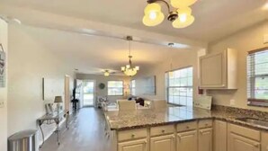 A spacious kitchen with granite countertops, white cabinets, and a central island. - Prime Location, 2 Bath/2 Bed Perfect Getaway (Dunedin)