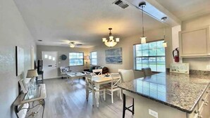 A spacious living area with a dining table, chairs, and a kitchen island with a granite countertop. - Prime Location, 2 Bath/2 Bed Perfect Getaway (Dunedin)