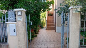 A gated entrance with a tiled pathway leading to a building. - SE118 - Senigallia, large three-room apartment with balcony (Senigallia)