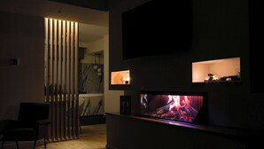 Ein modernes Wohnzimmer mit Kamin, Wand-Fernseher und minimalistischem Design.