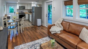 Um espaço compacto com cozinha compacta, área de jantar e sala de estar com sofá e mesa de centro.
