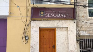 A building with a sign reading "EDIFICIO SEÑORAL" above a wooden door. - Apartahotel Señorial (Higuey)